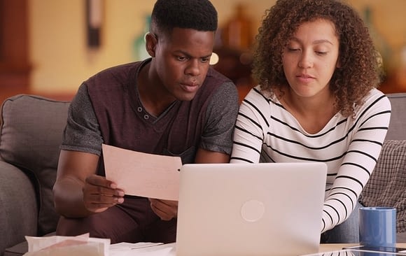 young couple working on documents on laptop